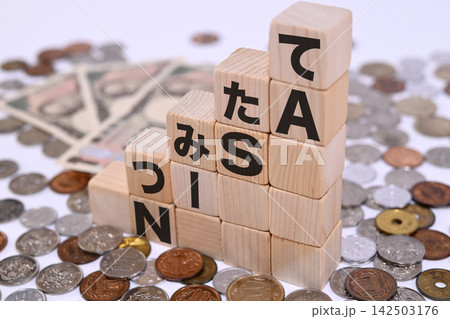 つみたてNISAのテキストと日本円の硬貨 つみたてNISAのテキストと日本円の硬貨 142503176