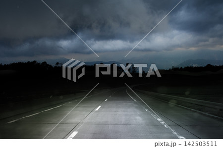 dark night road through forest and mountains, rain and storm, bad weather concept 142503511