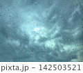 ガラス越しの雨粒と空模様 142503521