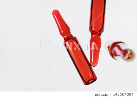 Red glass ampoules filled with liquid medicine, vaccine, or chemical solution for healthcare Red glass ampoules filled with liquid medicine, vaccine, or chemical solution for healthcare 142504004