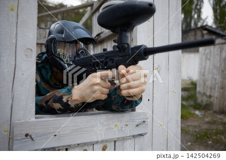 A soldier aims a weapon while looking out of a window on a training field A soldier aims a weapon while looking out of a window on a training field 142504269