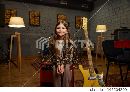 Young player happily preparing her lively yellow electric guitar for performance 142504290