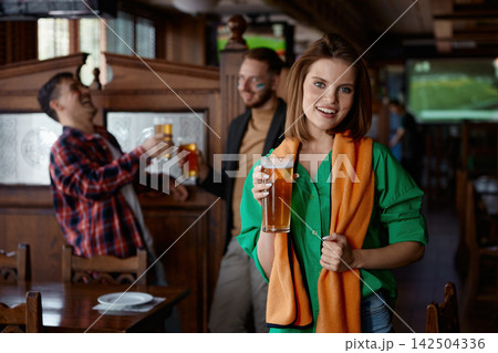 Happy woman in cozy bar observing friends celebrating with lively chatter Happy woman in cozy bar observing friends celebrating with lively chatter 142504336