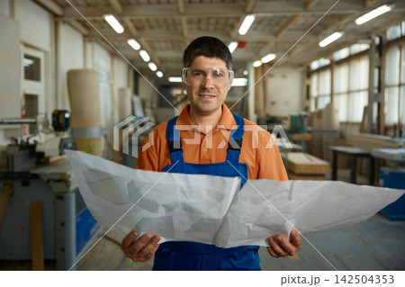 Plant supervisor evaluates production schematics and safety procedures diligently Plant supervisor evaluates production schematics and safety procedures diligently 142504353