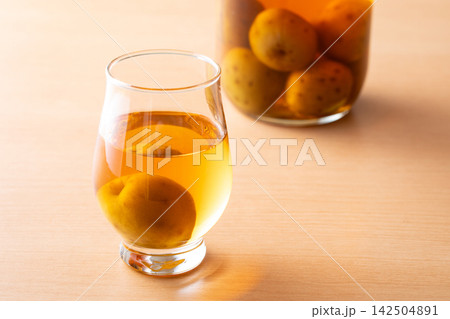 グラスに入った梅酒を飲む グラスに入った梅酒を飲む 142504891