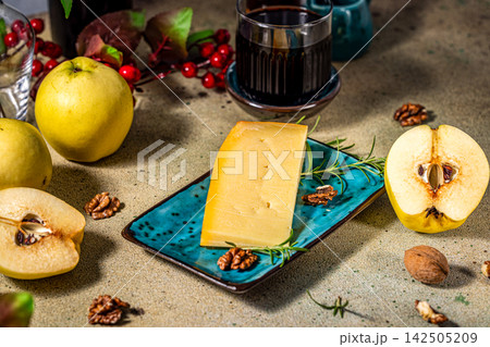 Wedge of cheese with quince and walnuts on serving platter Wedge of cheese with quince and walnuts on serving platter 142505209