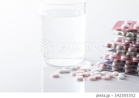 コップに入った水とサプリメントや色々な薬 コップに入った水とサプリメントや色々な薬 142505352