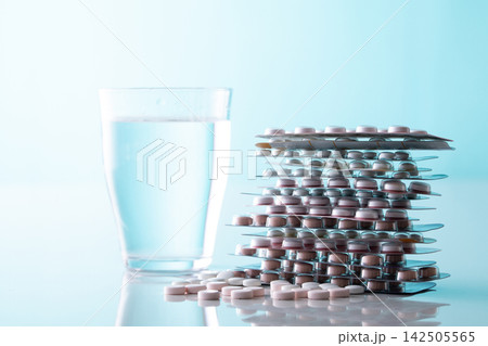 コップに入った水とサプリメントや色々な薬 コップに入った水とサプリメントや色々な薬 142505565