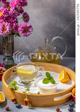 Relaxing tea time with yogurt and fresh fruits on wooden tray 142505756