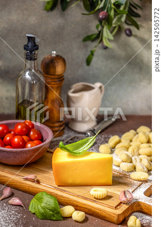 Potato gnocchi, cheese, tomato, garlic and basil leaves composing a tasty italian meal Potato gnocchi, cheese, tomato, garlic and basil leaves composing a tasty italian meal 142505772