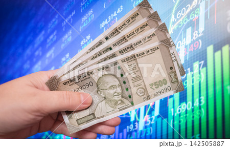 Photo of Indian 500 rupee banknotes placed and financial charts in the background. Photo of Indian 500 rupee banknotes placed and financial charts in the background. 142505887