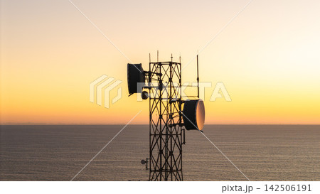 Telecommunications Tower with Microwave Dishes Above Ocean at Sunset Telecommunications Tower with Microwave Dishes Above Ocean at Sunset 142506191