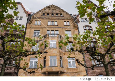 Ornate Historic Apartment Facade Framed by Plane Trees 142506197