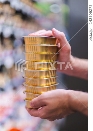 Woman Holding Tall Stack of Gold Canned Pet Food Woman Holding Tall Stack of Gold Canned Pet Food 142506272
