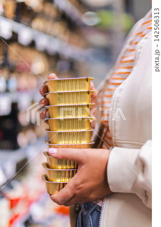 Woman Holding Stack of Gold Canned Pet Food Woman Holding Stack of Gold Canned Pet Food 142506313