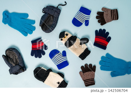 Different types of winter gloves and mittens on a blue background Different types of winter gloves and mittens on a blue background 142506704