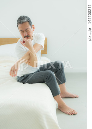 ベッドで悩む中高年男性　 142508253
