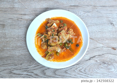 spicy fried pork cartilage with curry and eggplant on plate  142508322