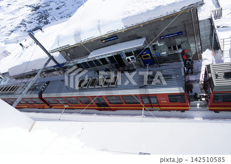 高台から見下ろすアイガーグレッチャー駅と、雪景色の中を佇む登山列車のジオラマ風ビュー 142510585