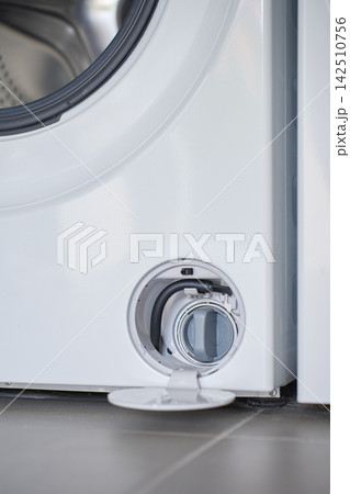 Open drain filter compartment at bottom of front loading washing machine Open drain filter compartment at bottom of front loading washing machine 142510756