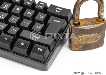 Close-up of an old rusty padlock beside a black mechanical keyboard, illustrating the concept of cybersecurity, online privacy, and the consequences of pressing enter Close-up of an old rusty padlock beside a black mechanical keyboard, illustrating the concept of cybersecurity, online privacy, and the consequences of pressing enter 142510926