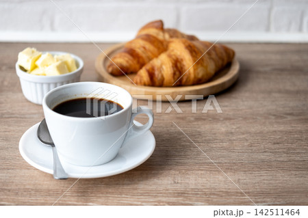 Black coffee with croissants and butter Black coffee with croissants and butter 142511464