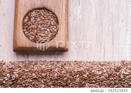 linseed seeds in container and spoon on the table linseed seeds in container and spoon on the table 142511835