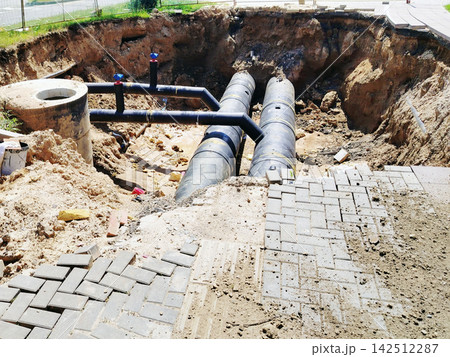 Underground Pipes and Excavation at Urban Construction Site With Exposed Sewer Lines and Paving. Underground Pipes and Excavation at Urban Construction Site With Exposed Sewer Lines and Paving. 142512287