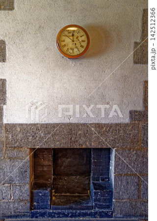 Vintage Circular Wall Clock Above Granite Fireplace in Castle Vintage Circular Wall Clock Above Granite Fireplace in Castle 142512366