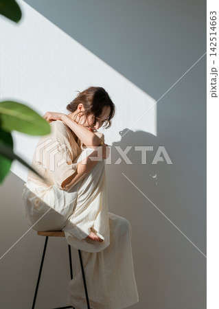 陽射しの中で肩に手を添える40代女性、光と影が印象的なポートレート 陽射しの中で肩に手を添える40代女性、光と影が印象的なポートレート 142514663