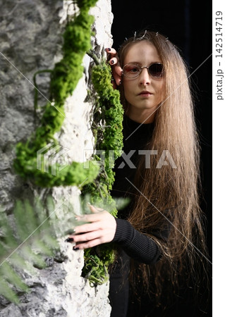 Young writer with reflective mood near aged mosscovered opening 142514719