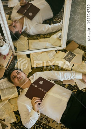 Individual lying on rug observing with distant thoughtful expression 142514729