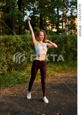 White woman celebrating dumbbell raise, victorious athlete White woman celebrating dumbbell raise, victorious athlete 142514776