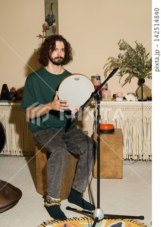 Artist Demonstrating Live Music Performance Using Microphone Camera Setup In Small Studio Environment 142514840