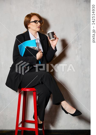 Relaxed businesswoman sitting on stool during casual meeting break 142514930