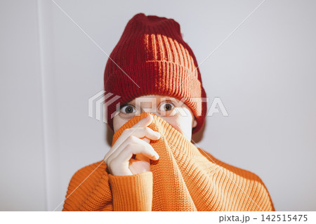 Boy Wrapped in Bright Orange Knitted Sweater Wearing Red Beanie Boy Wrapped in Bright Orange Knitted Sweater Wearing Red Beanie 142515475