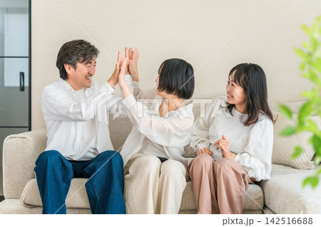 笑顔でハイタッチをする家族、喜びを分かち合う仲良し親子 142516688