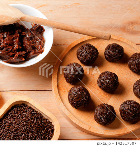 Classic Brazilian chocolate and sprinkle treat known as brigadeiro, presented in a rustic style on a wooden table. Classic Brazilian chocolate and sprinkle treat known as brigadeiro, presented in a rustic style on a wooden table. 142517307