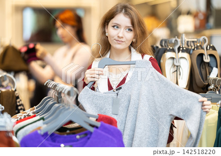 Young woman search and choose sweater Young woman search and choose sweater 142518220
