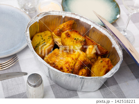 Fried chicken with baked potatoes served in foil Fried chicken with baked potatoes served in foil 142518221