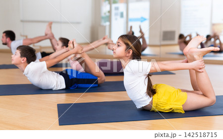 Family of four practicing yoga at gym Family of four practicing yoga at gym 142518715