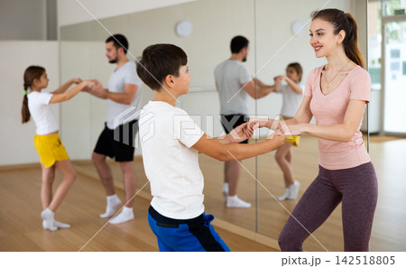 Mother and young son learning to dance waltz together Mother and young son learning to dance waltz together 142518805