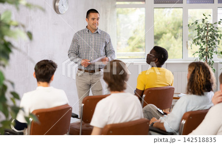 Young man teacher reading lecture for a group of guys Young man teacher reading lecture for a group of guys 142518835