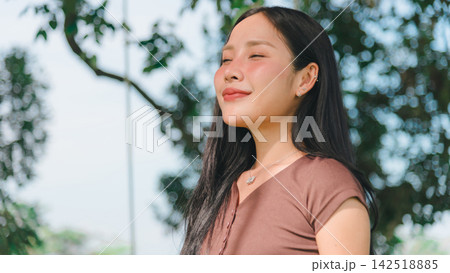 Asian woman breathing fresh air, green forest surrounding peaceful person relaxing outdoors, enjoying calm nature environment with deep relaxation and health concept Asian woman breathing fresh air, green forest surrounding peaceful person relaxing outdoors, enjoying calm nature environment with deep relaxation and health concept 142518885
