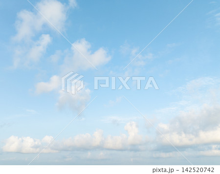 Bright blue tropical sky with soft white cumulus clouds during calm morning weather. Spacious natural background for environmental, seasonal design, weather, climate, nature, wellness concepts. Bright blue tropical sky with soft white cumulus clouds during calm morning weather. Spacious natural background for environmental, seasonal design, weather, climate, nature, wellness concepts. 142520742