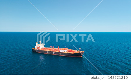 Aerial view of LPG tanker vessel anchored in open sea with vast blue water and clear horizon Aerial view of LPG tanker vessel anchored in open sea with vast blue water and clear horizon 142521210