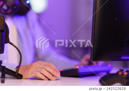 Cropped hand holding computer mouse on desk for gaming livestream and podcasting Cropped hand holding computer mouse on desk for gaming livestream and podcasting 142522628