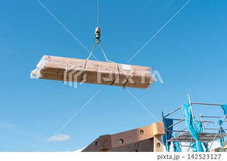 クレーンで木材を吊り上げる木造住宅の建築現場。上棟時の資材搬入 142523127