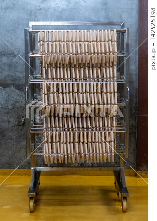 Fresh Raw Sausages Hanging on Racks in Food Processing Factory Fresh Raw Sausages Hanging on Racks in Food Processing Factory 142525198