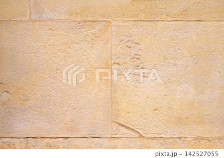 Ancient architectural wall with rectangular stone blocks. Aged mineral plaster and weathered seams. Abstract architecture background Ancient architectural wall with rectangular stone blocks. Aged mineral plaster and weathered seams. Abstract architecture background 142527055